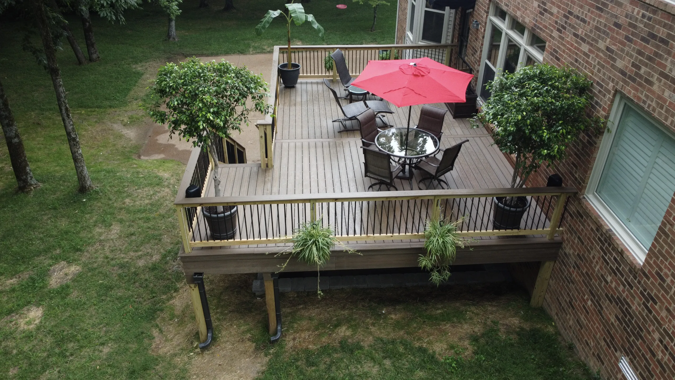 aerial-view-of-the-raised-residential-deck-with-outdoor-living-area-and-big-potted-plants-on-the-brick-house-in-franklin-tn